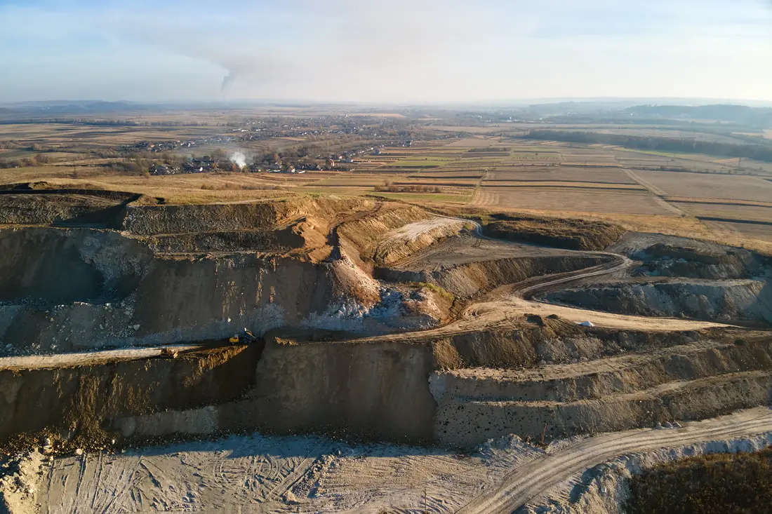 Aerial view of an open pit mine with excavators and dump trucks