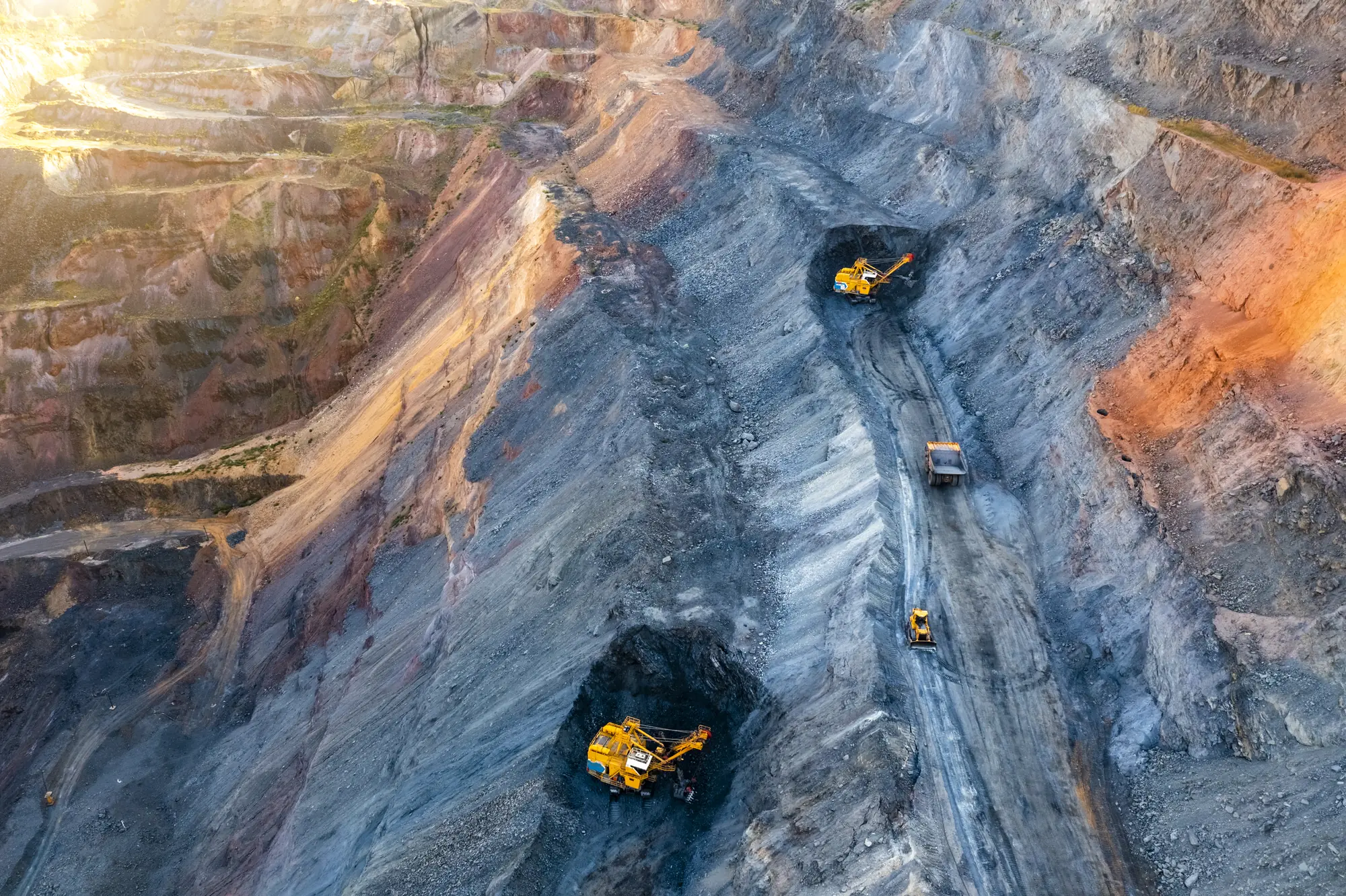 Aerial view of an open pit mine with excavators and haul roads